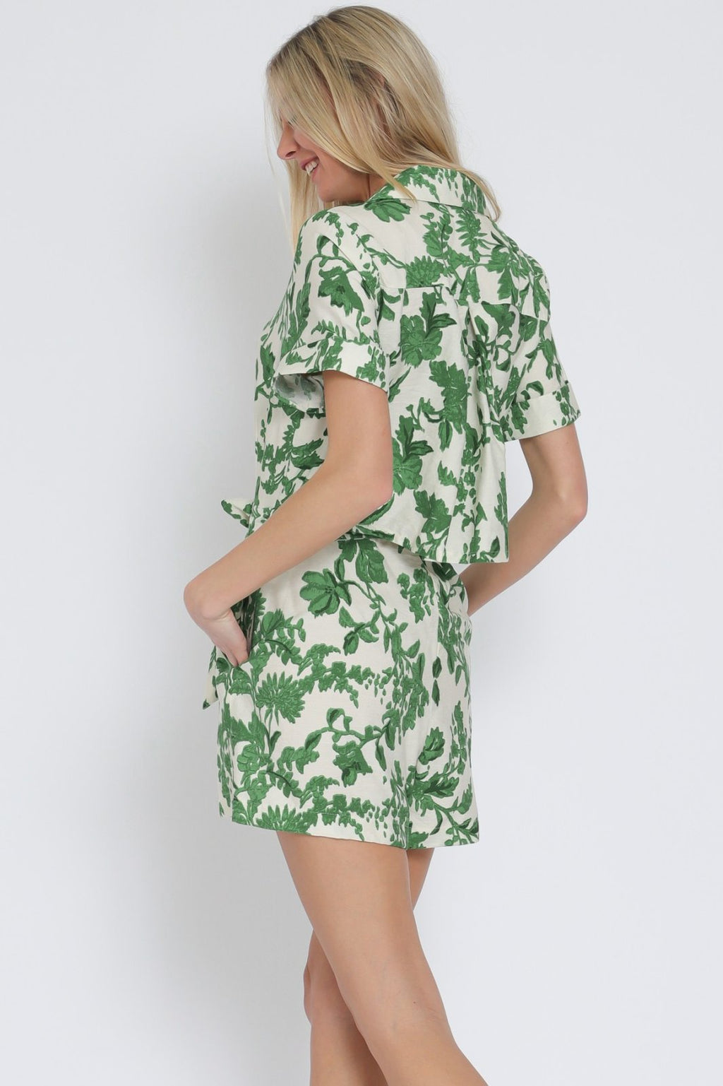 Ivory and green short sleeve romper from a coastal boutique, perfect for beach days and summer vacations.