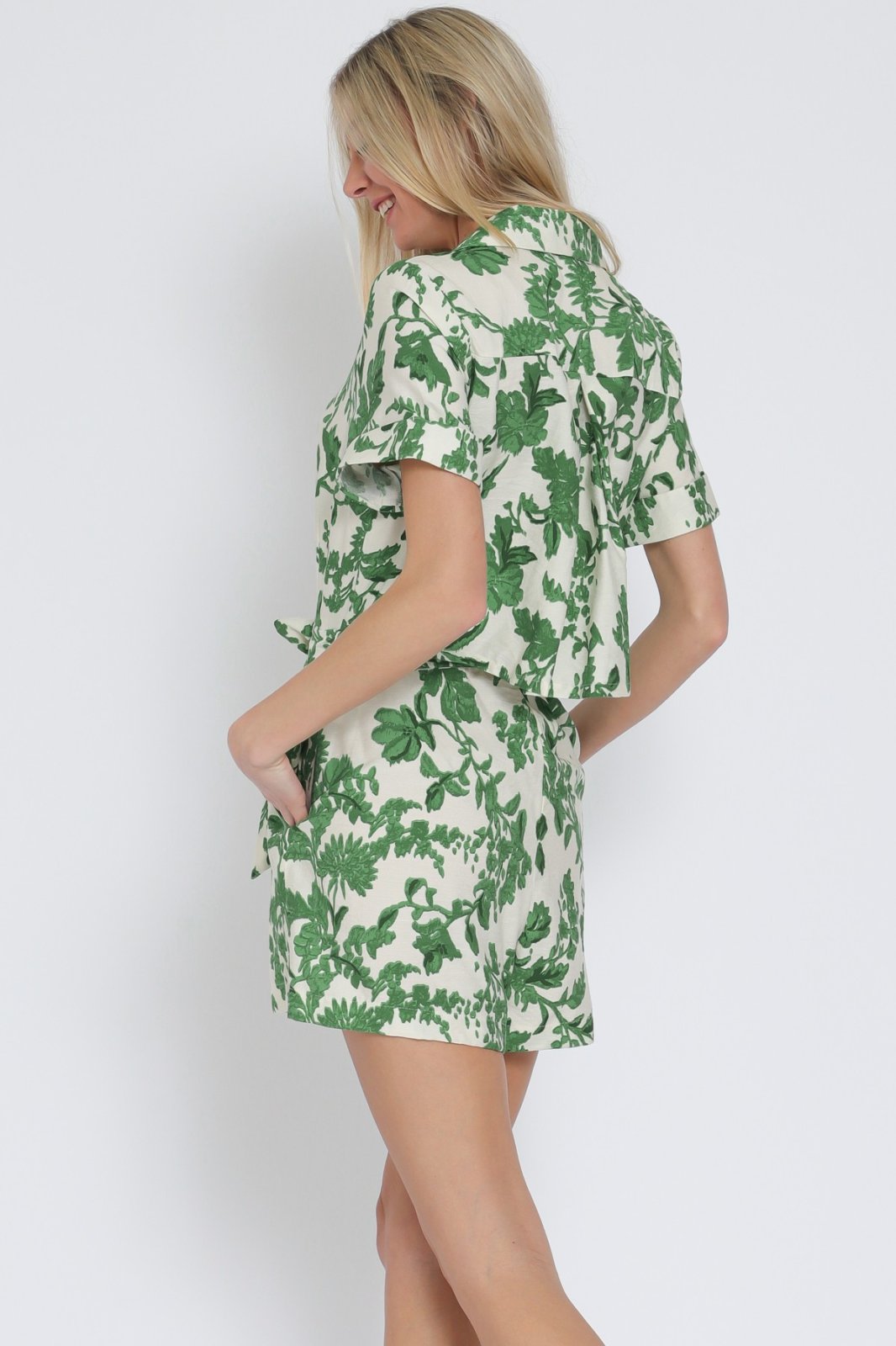Ivory and green short sleeve romper from a coastal boutique, perfect for beach days and summer vacations.