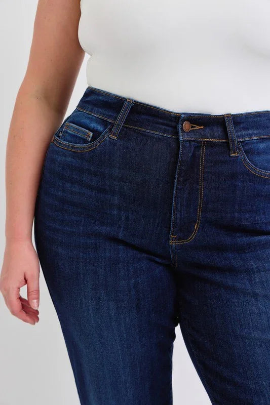 Model wearing JUDY BLUE high waisted straight dark jeans, showcasing curvy plus size fashion at a coastal boutique.