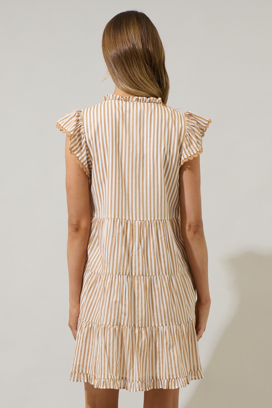 Back view of taupe striped mini dress with ruffle sleeves, perfect for stylish coastal boutique clothing and summer outings.