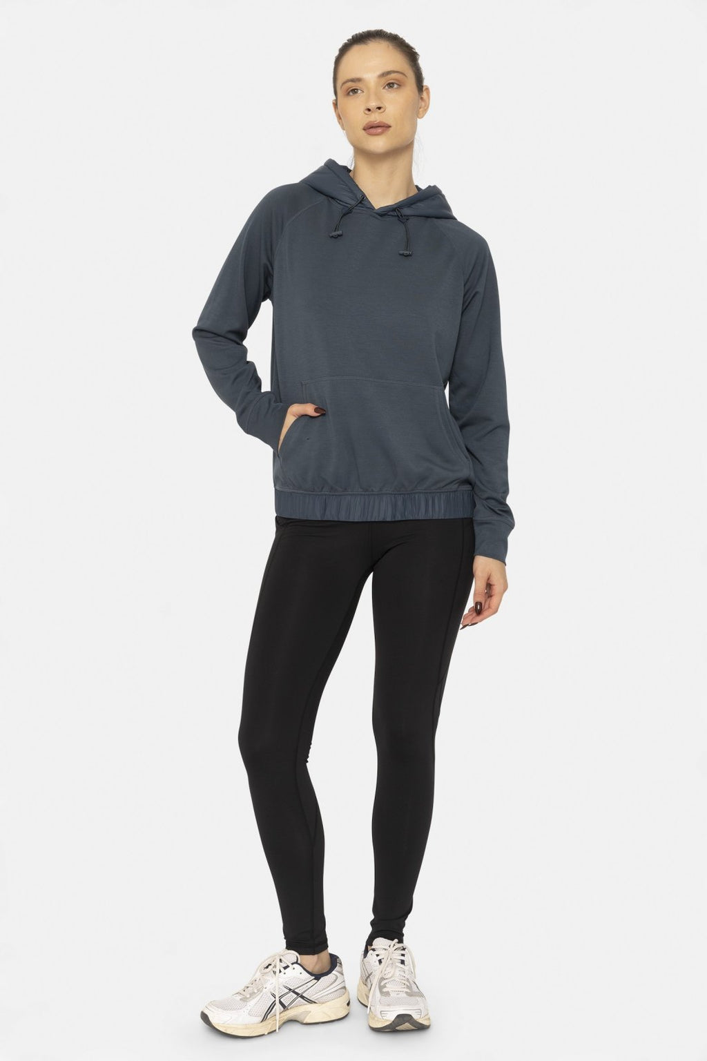 Stylish woman in a blue hoodie and black high-waist leggings, perfect for coastal boutique clothing and active lifestyles.