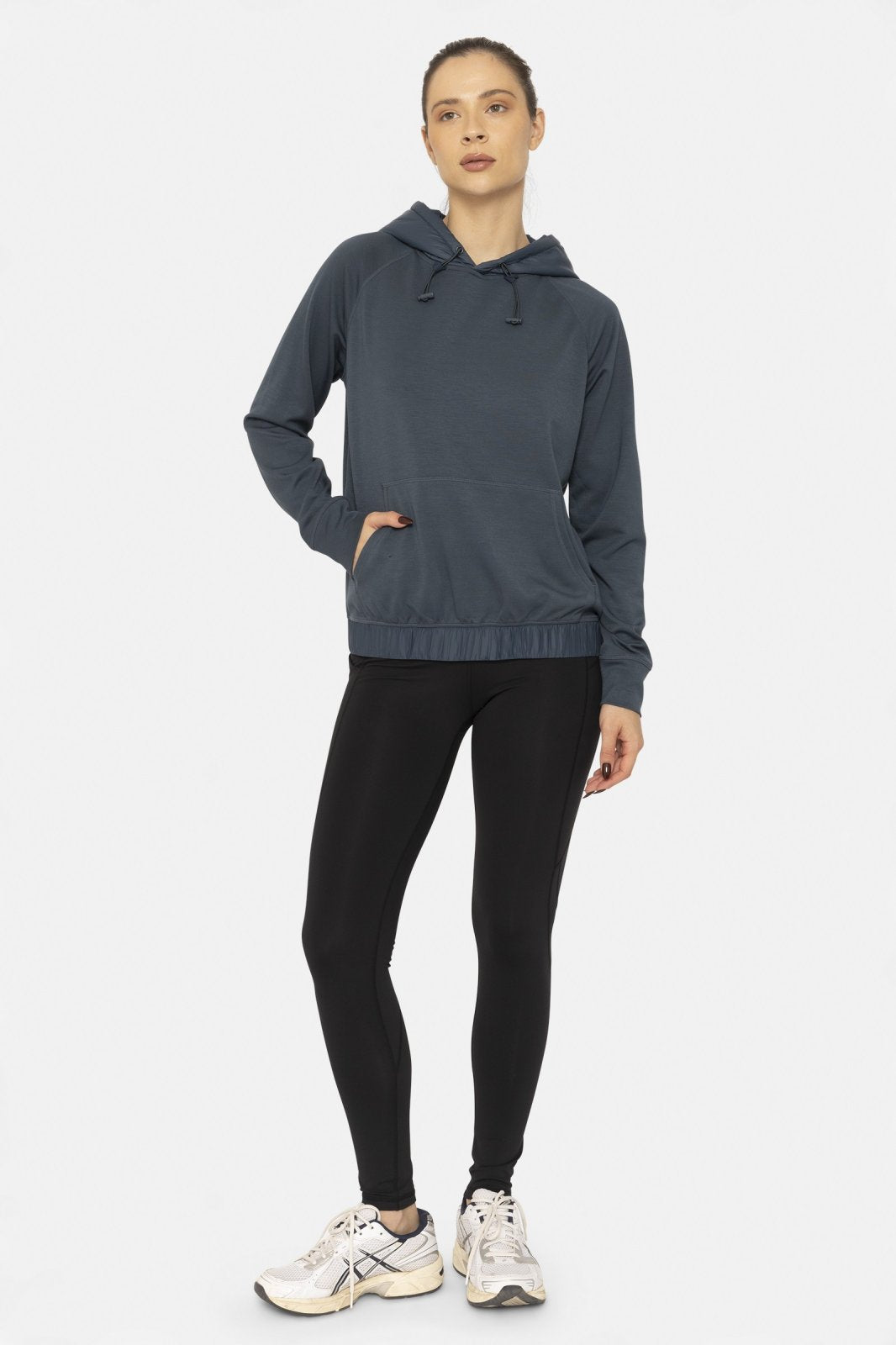 Stylish woman in a blue hoodie and black high-waist leggings, perfect for coastal boutique clothing and active lifestyles.