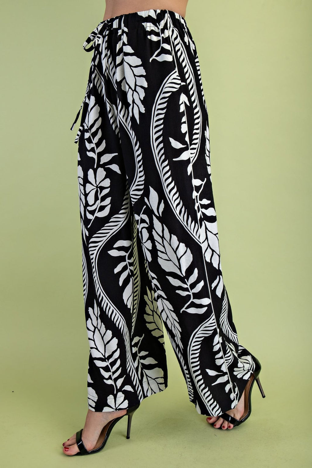 Stylish black patterned leaf drawstring pants for women, ideal for coastal boutique clothing or tropical vacation dresses.