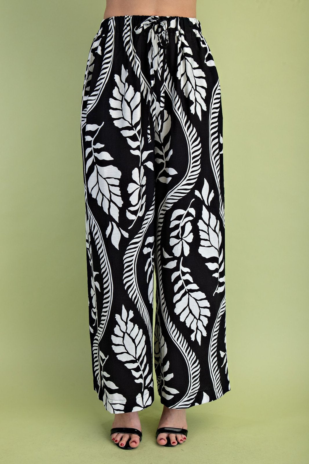 Stylish black leaf pattern drawstring pants from a coastal boutique, perfect for beach outings and curvy plus size fashion.