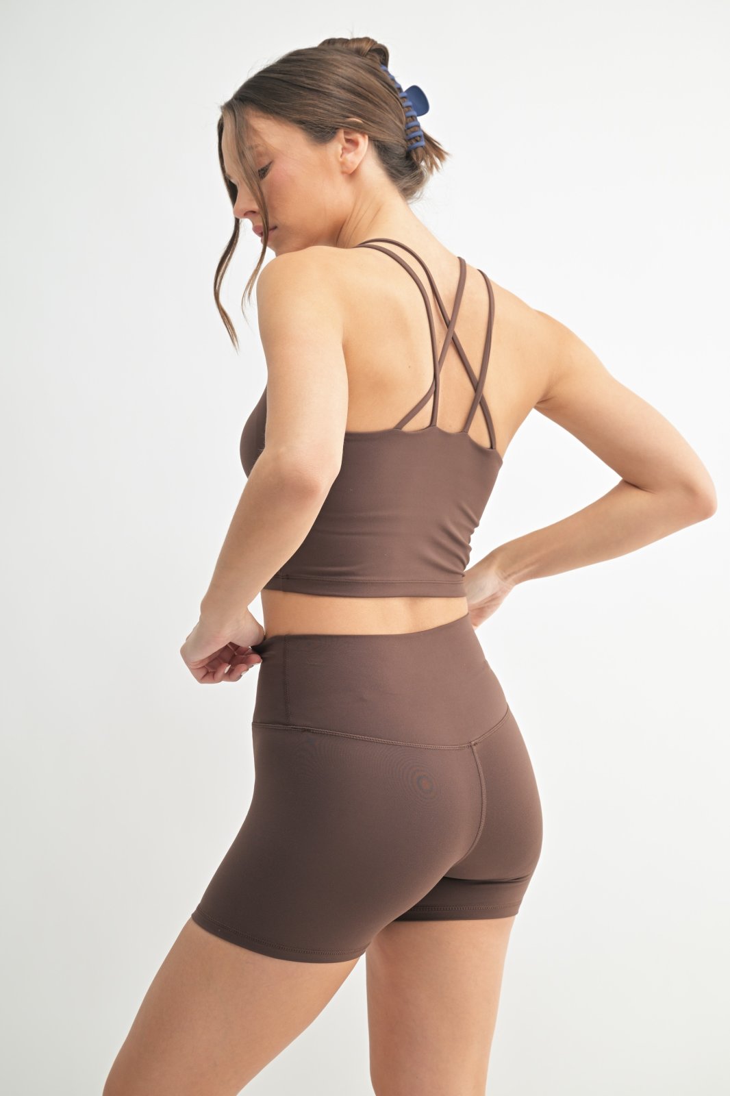 Stylish MONO B criss-cross sports bra in rich soil color, perfect for activewear and curvy plus size fashion at coastal boutiques.
