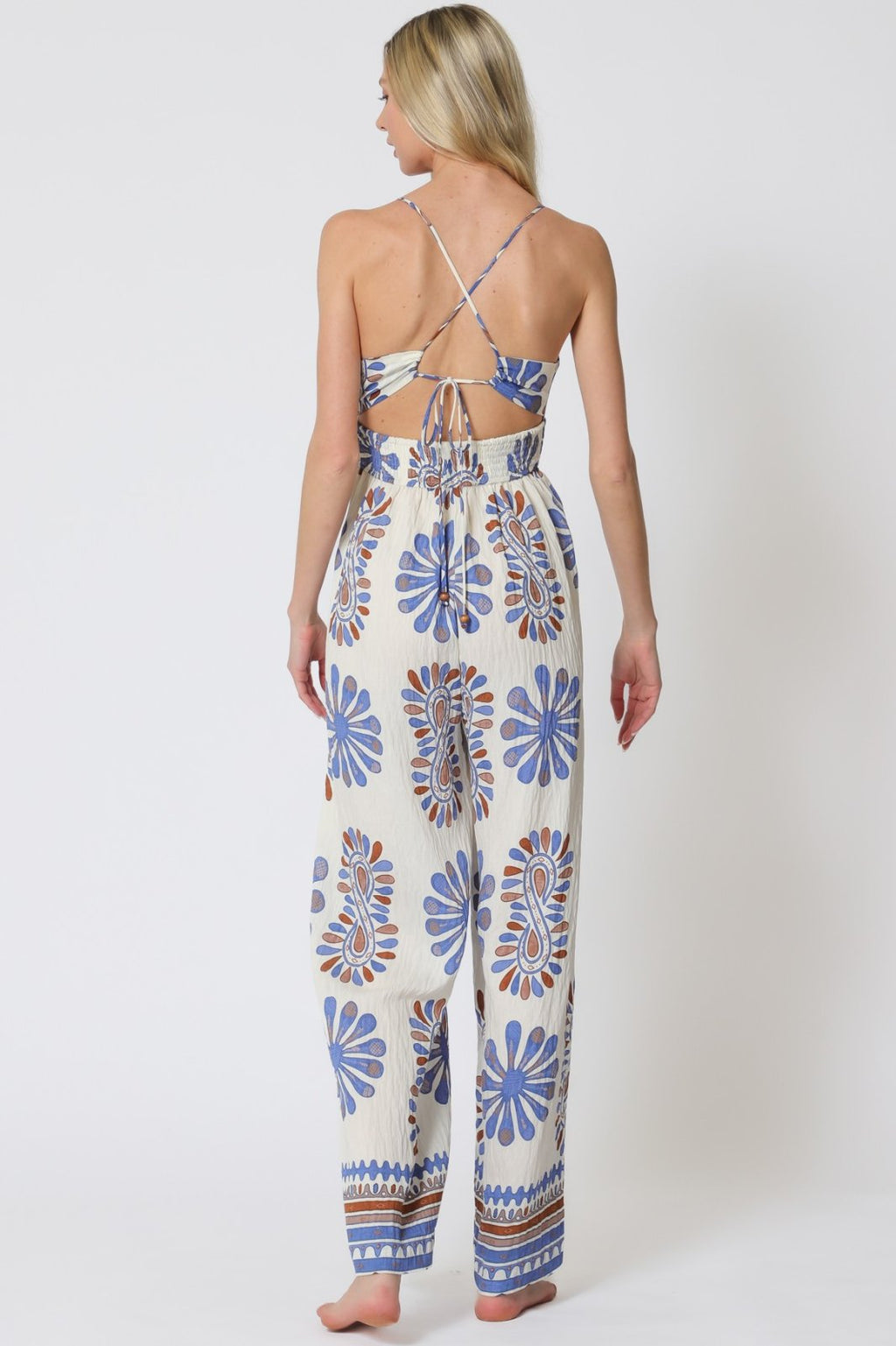 Stylish blue print sleeveless jumpsuit with tie-back, perfect for coastal boutique clothing and tropical vacations.