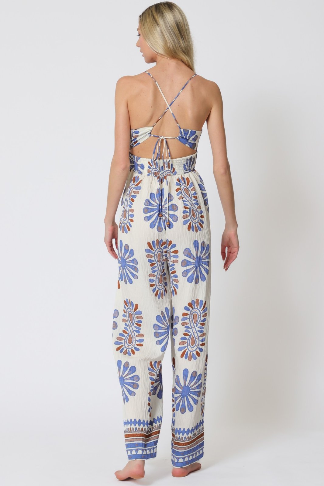 Stylish blue print sleeveless jumpsuit with tie-back, perfect for coastal boutique clothing and tropical vacations.