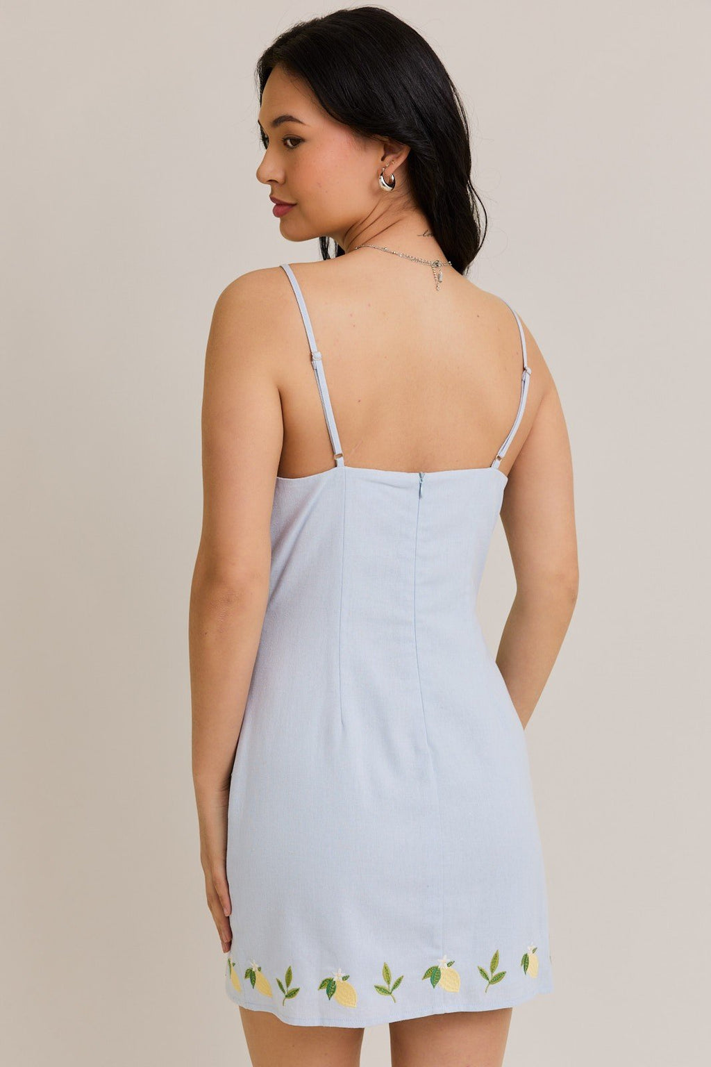 Back view of a light blue lemon drop mini dress with spaghetti straps, perfect for summer outings from a coastal boutique.