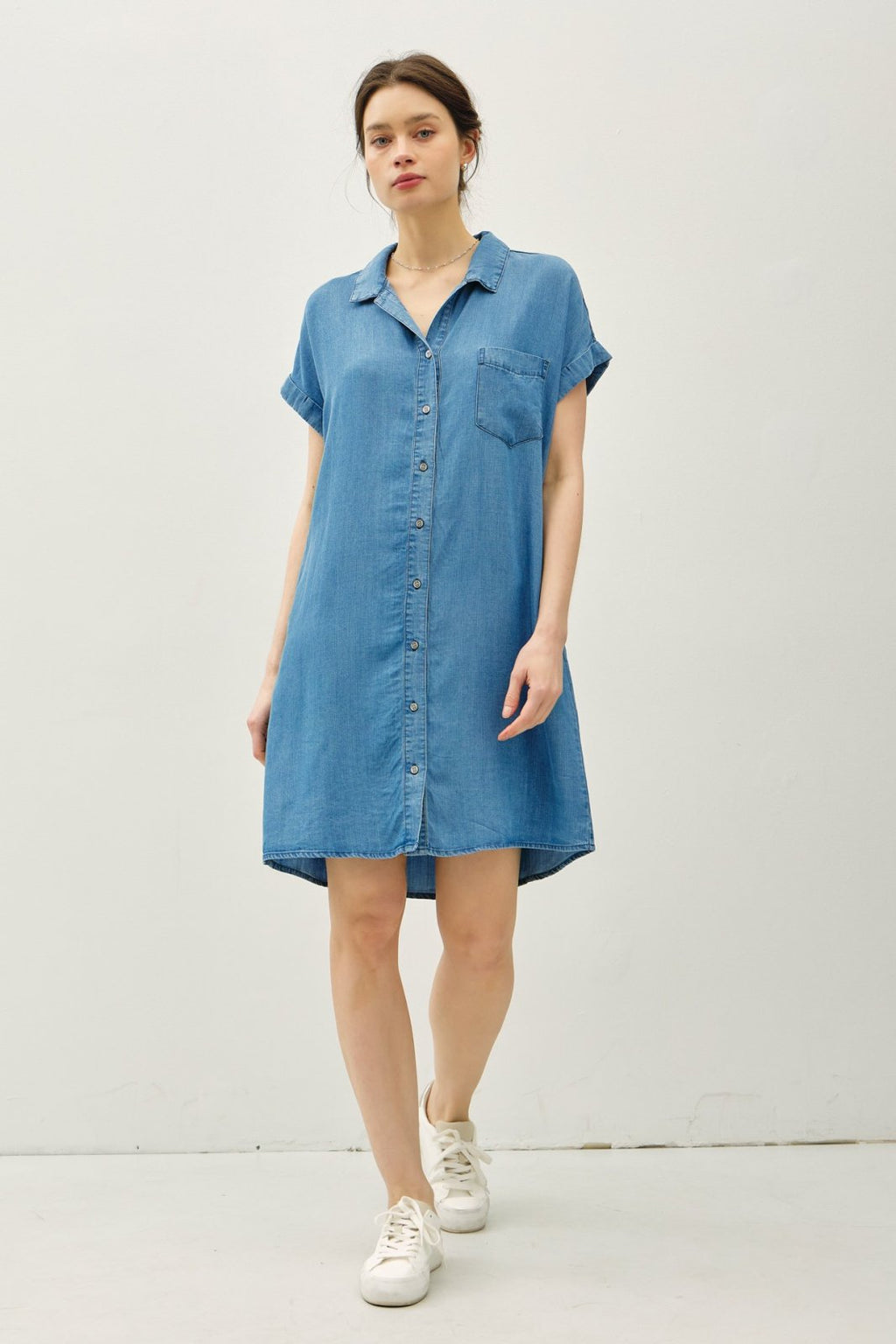 Model wearing Kelby Dress, a medium wash Tencel denim shirt dress, ideal for coastal boutique clothing and beach styles.