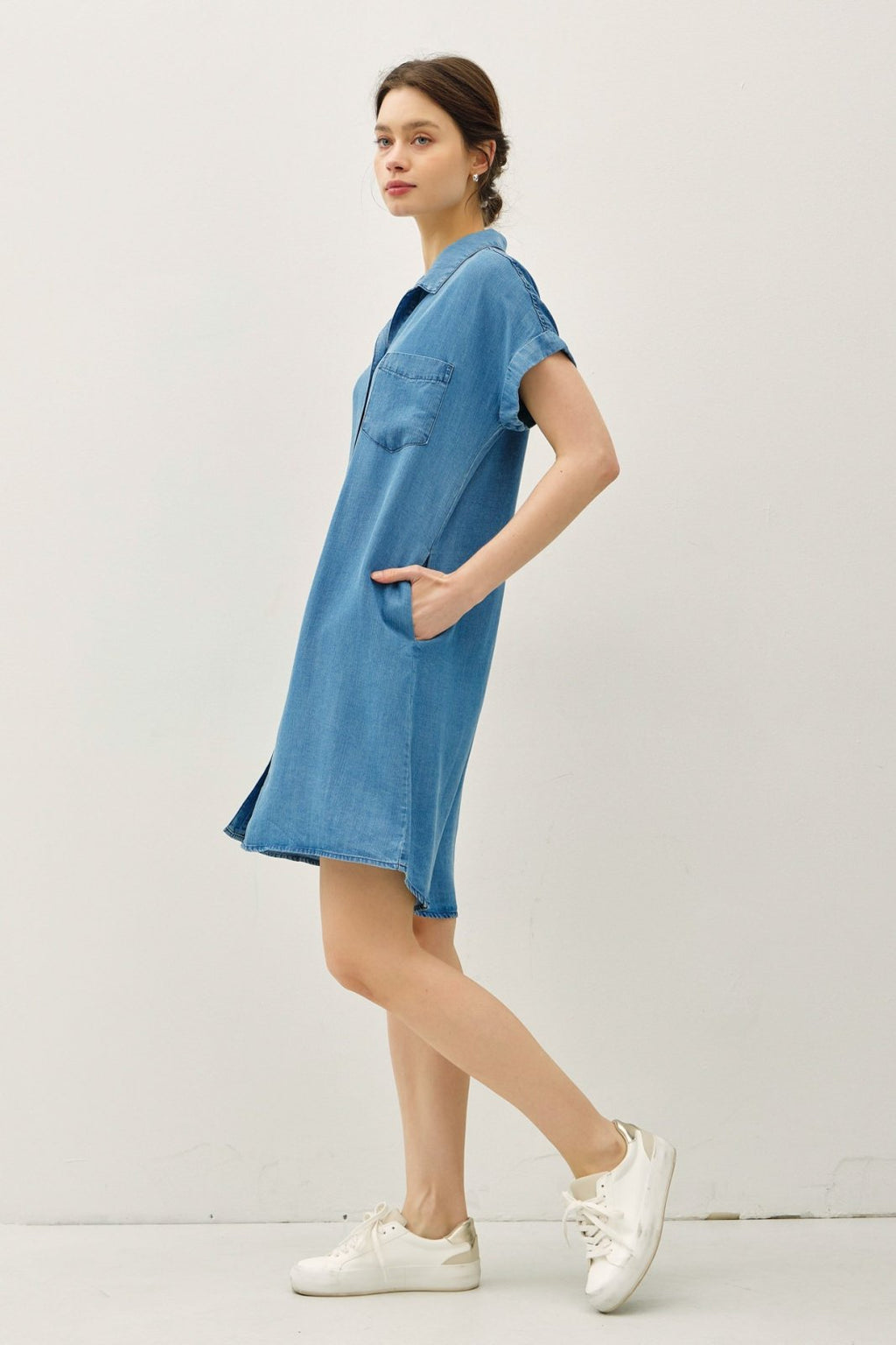 Coastal boutique clothing: Model in a medium wash denim shirt dress, perfect for beach days and stylish summer outings.