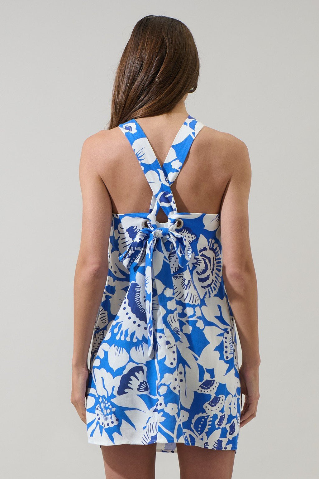 Women's blue and white floral halter dress with criss-cross back, perfect for coastal boutique clothing and summer outings.