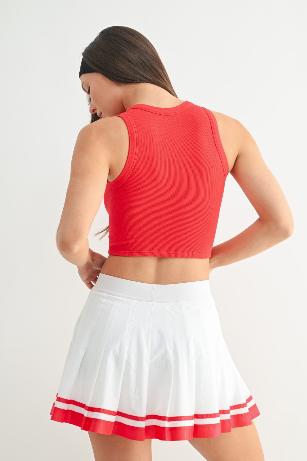 Stylish red muscle tank top paired with a white skirt, perfect for coastal boutique clothing and summer outings.