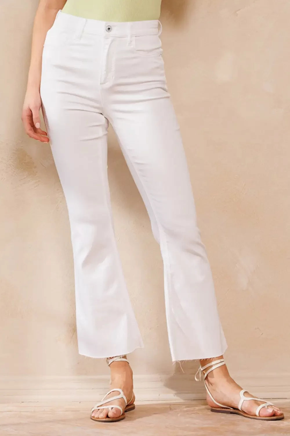SP HIGH RISE KICK FLARE JEANS WITH RAW CUT HEM (WHITE) showcased with trendy footwear for summer outfits Texas.