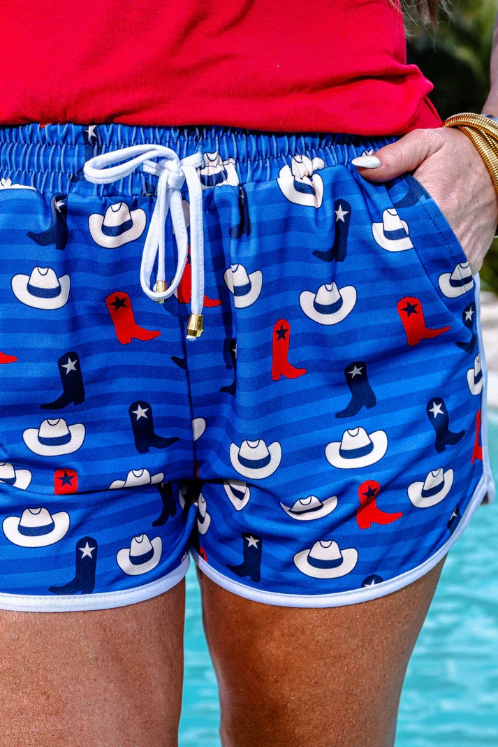 Hey There Cowboy Shorts featuring playful cowboy hats and boots pattern, perfect for trendy coastal style. Free shipping available.