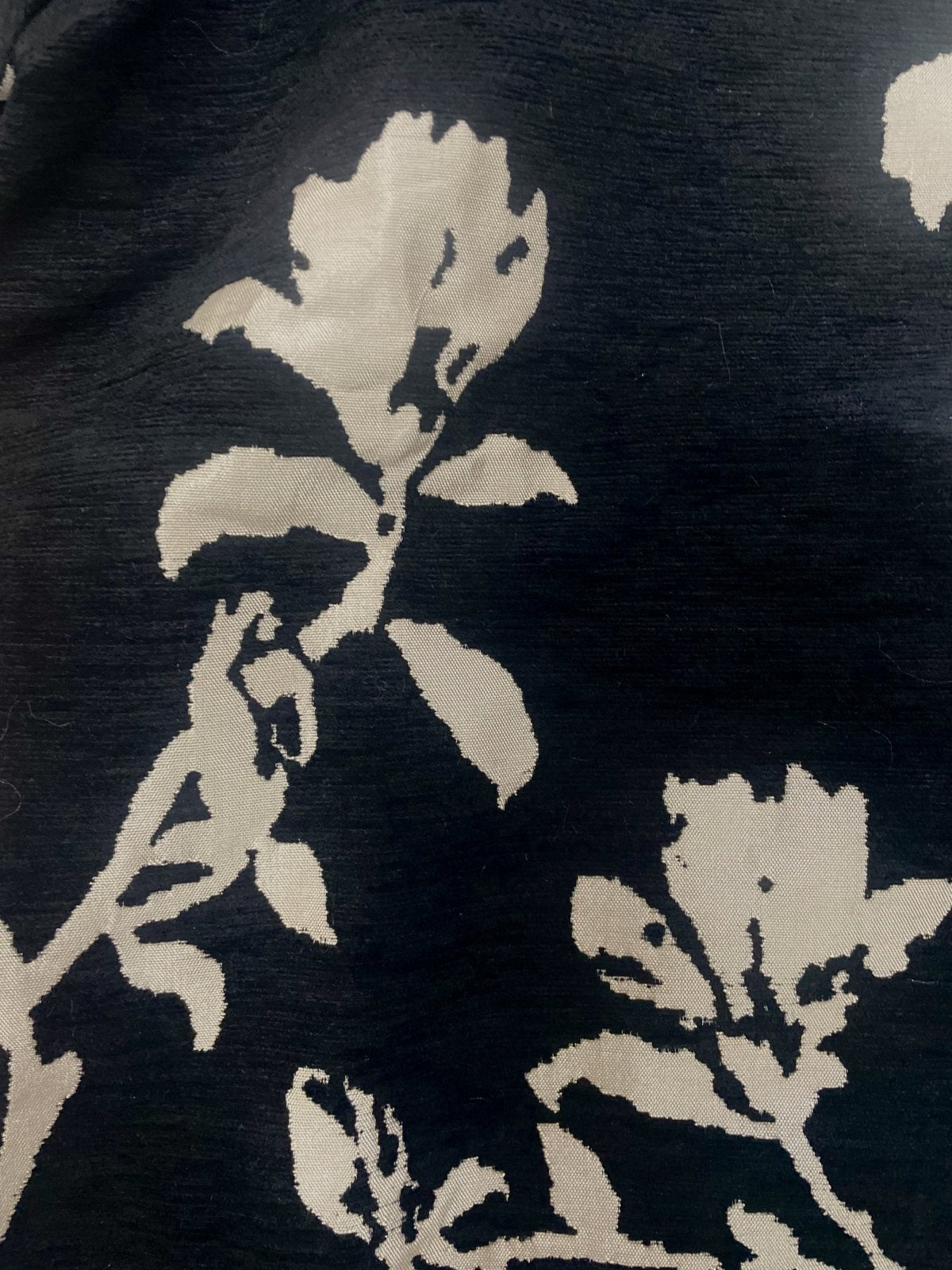 Close-up of a floral pattern in black and cream, highlighting stylish design perfect for coastal boutique clothing.