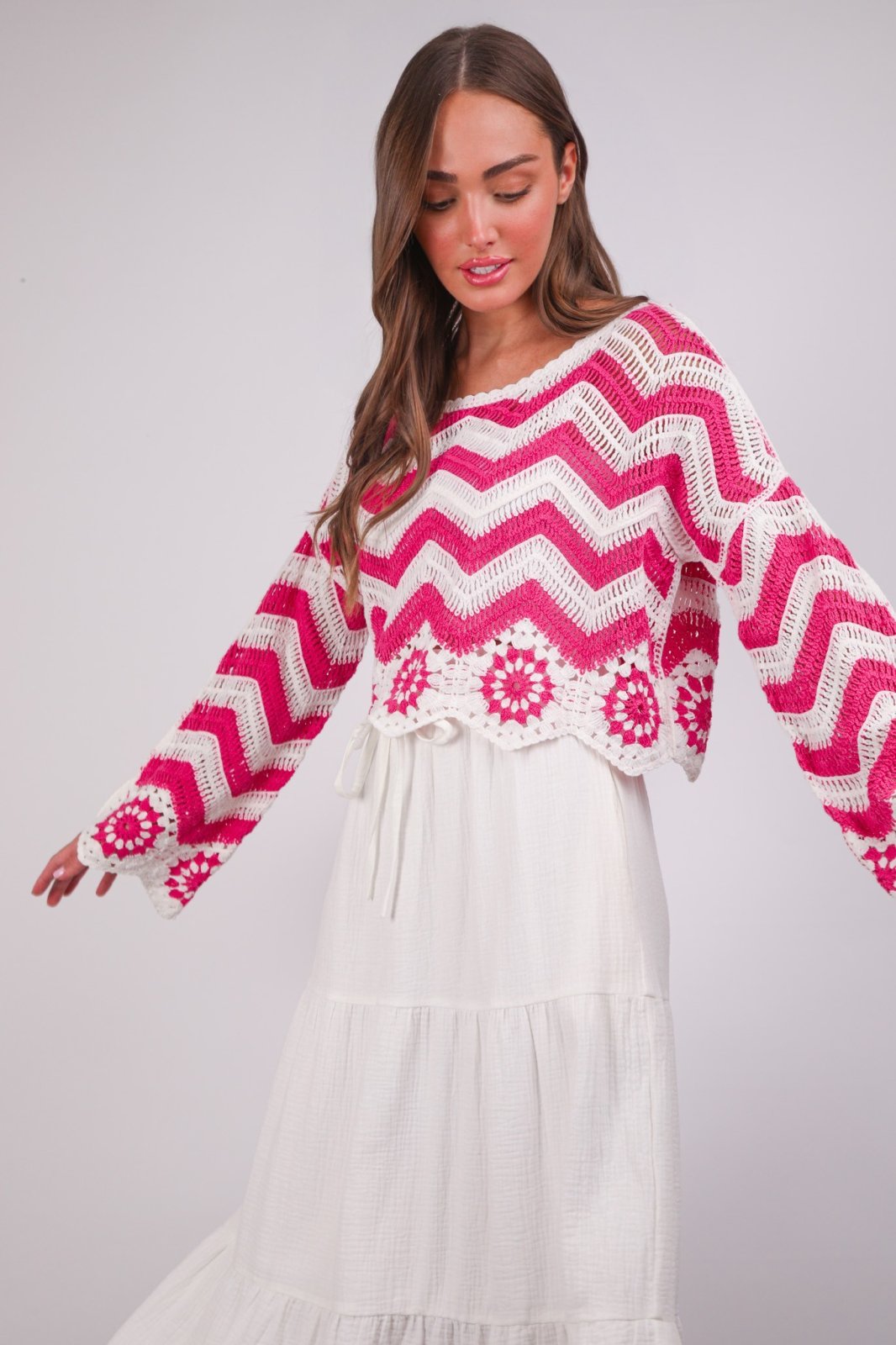 Pink Chevron Crochet Knit Top featuring floral patterns at a coastal boutique, ideal for stylish layering and tropical vacations.