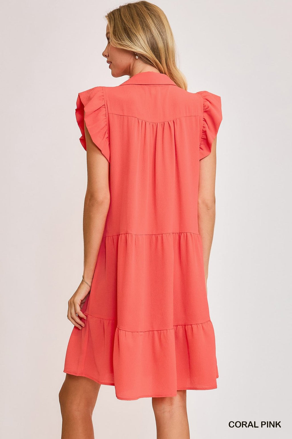 Back view of Janey Dress in coral pink, perfect for coastal boutique clothing and beach vacations, showcasing trendy women's fashion.