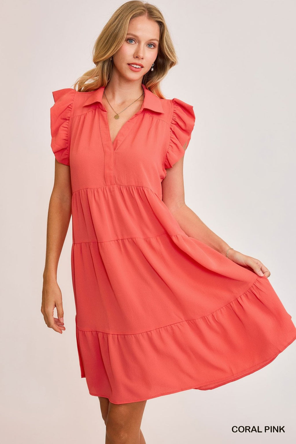 Coral pink Janey dress featuring ruffled sleeves, perfect for coastal boutique clothing and tropical vacation dresses.