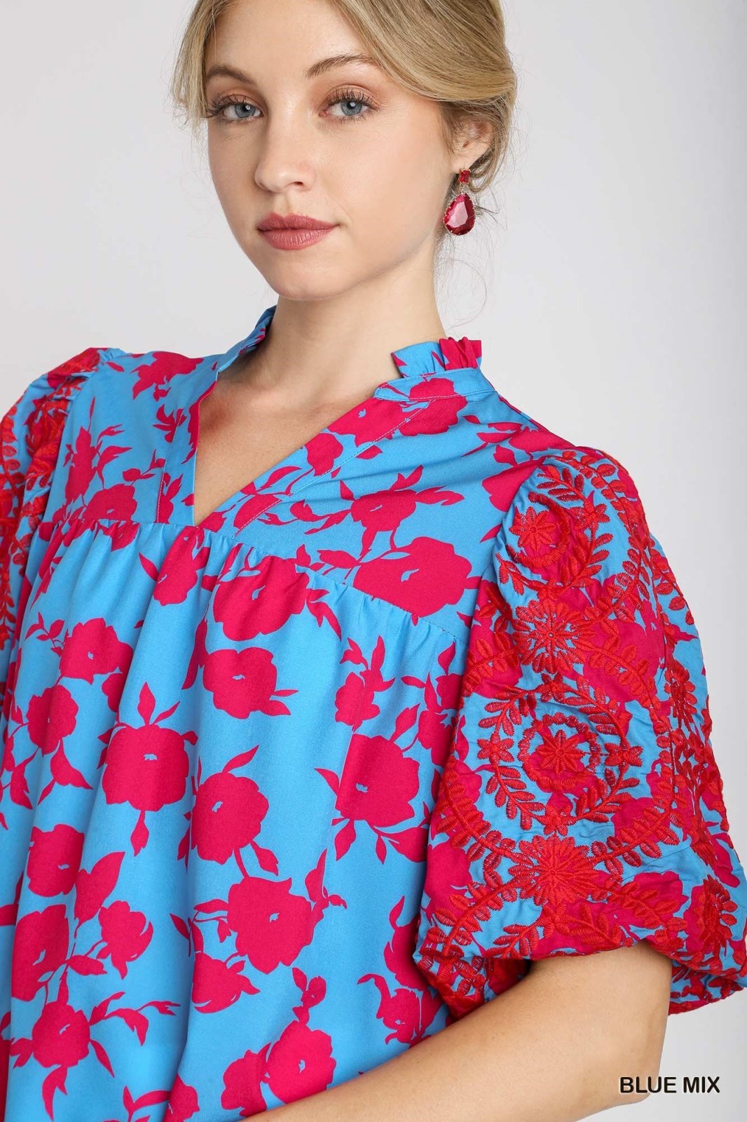 Chic two-tone blue split neck Lori Top with embroidered pink puff sleeves, perfect for coastal boutique clothing styles.