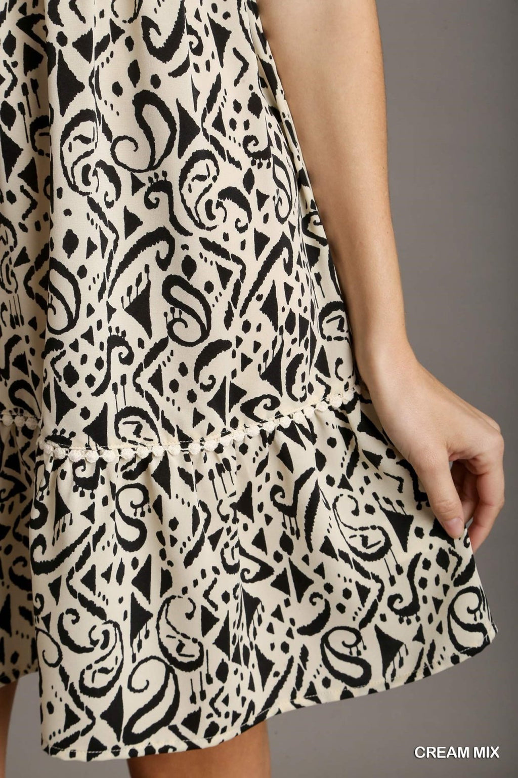 Close-up of the Kara Dress from Raggdoll Boutique featuring trendy coastal style in a cream mix pattern.