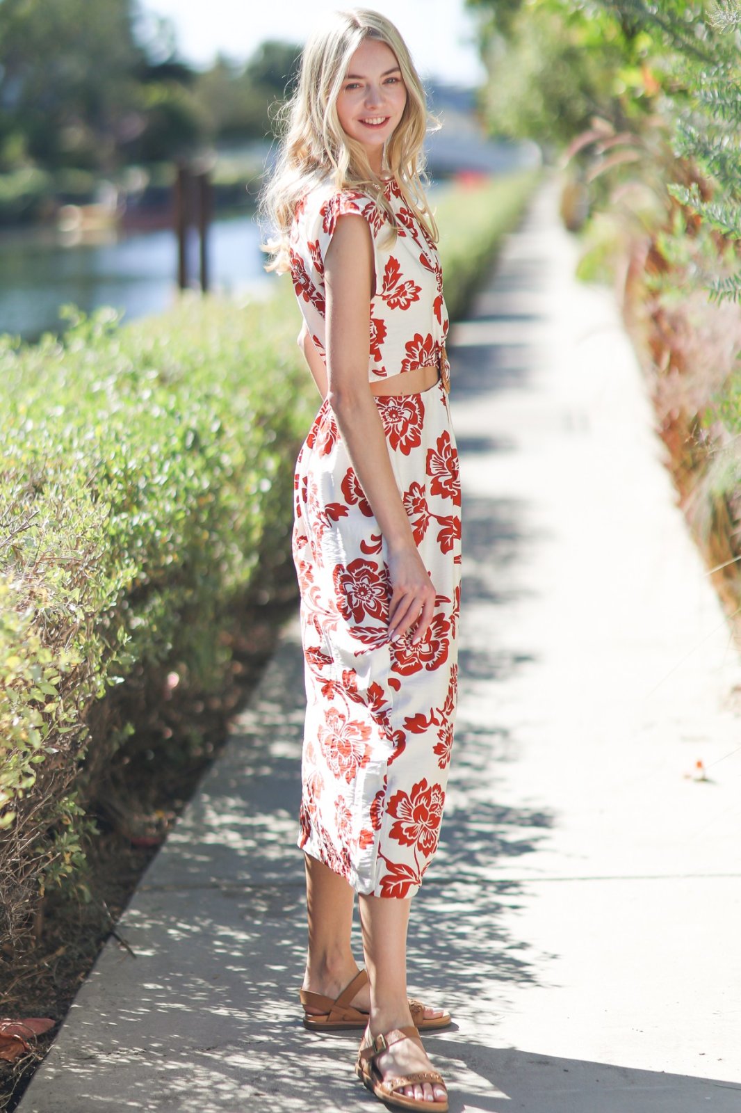 Woman in BECCA dress, ivory/rust floral midi, ideal for coastal boutique clothing and tropical vacations. Perfect beach dress.
