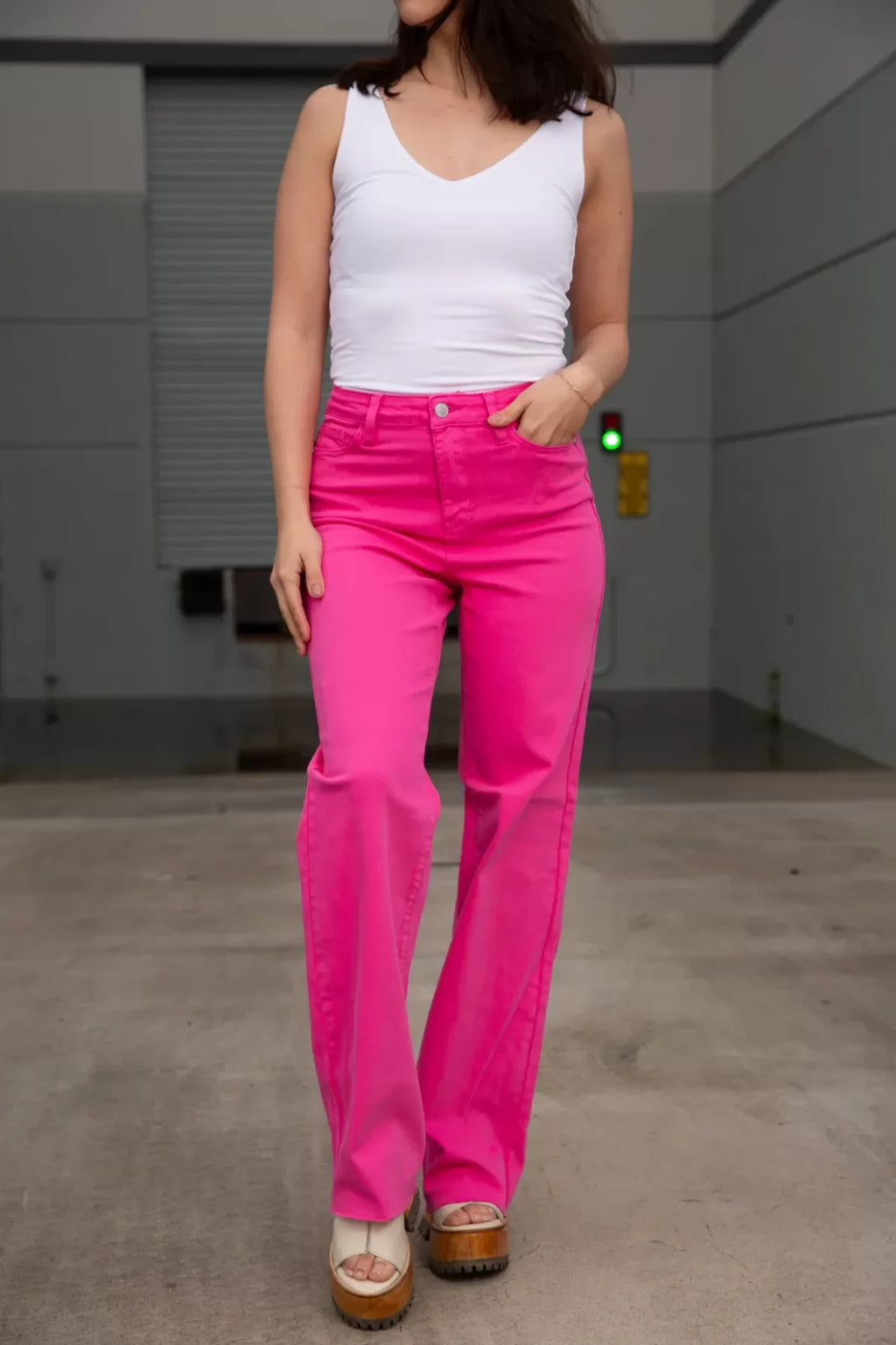 Woman wearing JUDY BLUE HOT PINK DYED 90's STRAIGHT JEAN at Raggdoll Boutique, showcasing trendy coastal style.