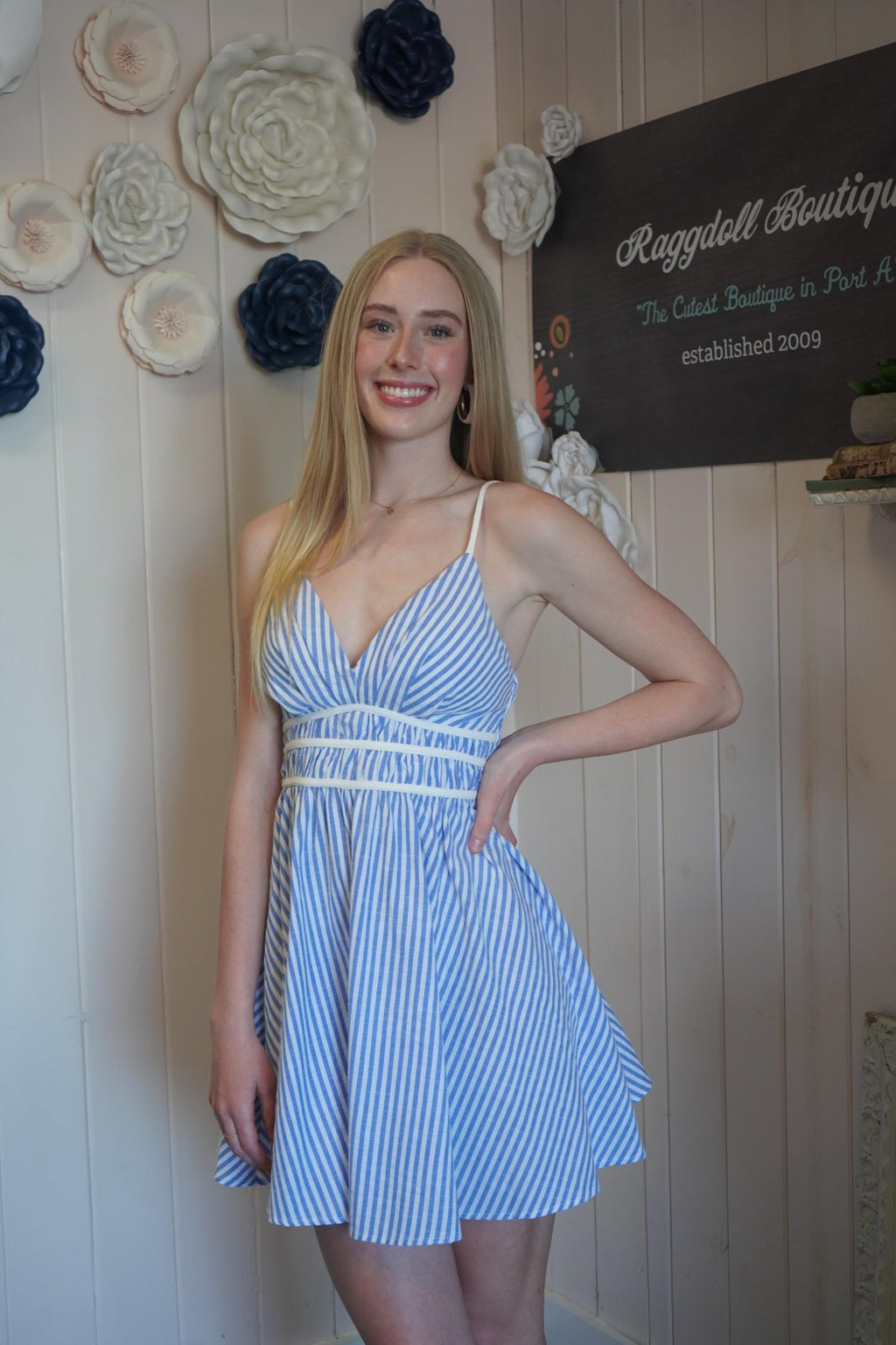 Model wearing the Emery Dress, a blue & white mini dress from a Port Aransas boutique, ideal for summer outings.
