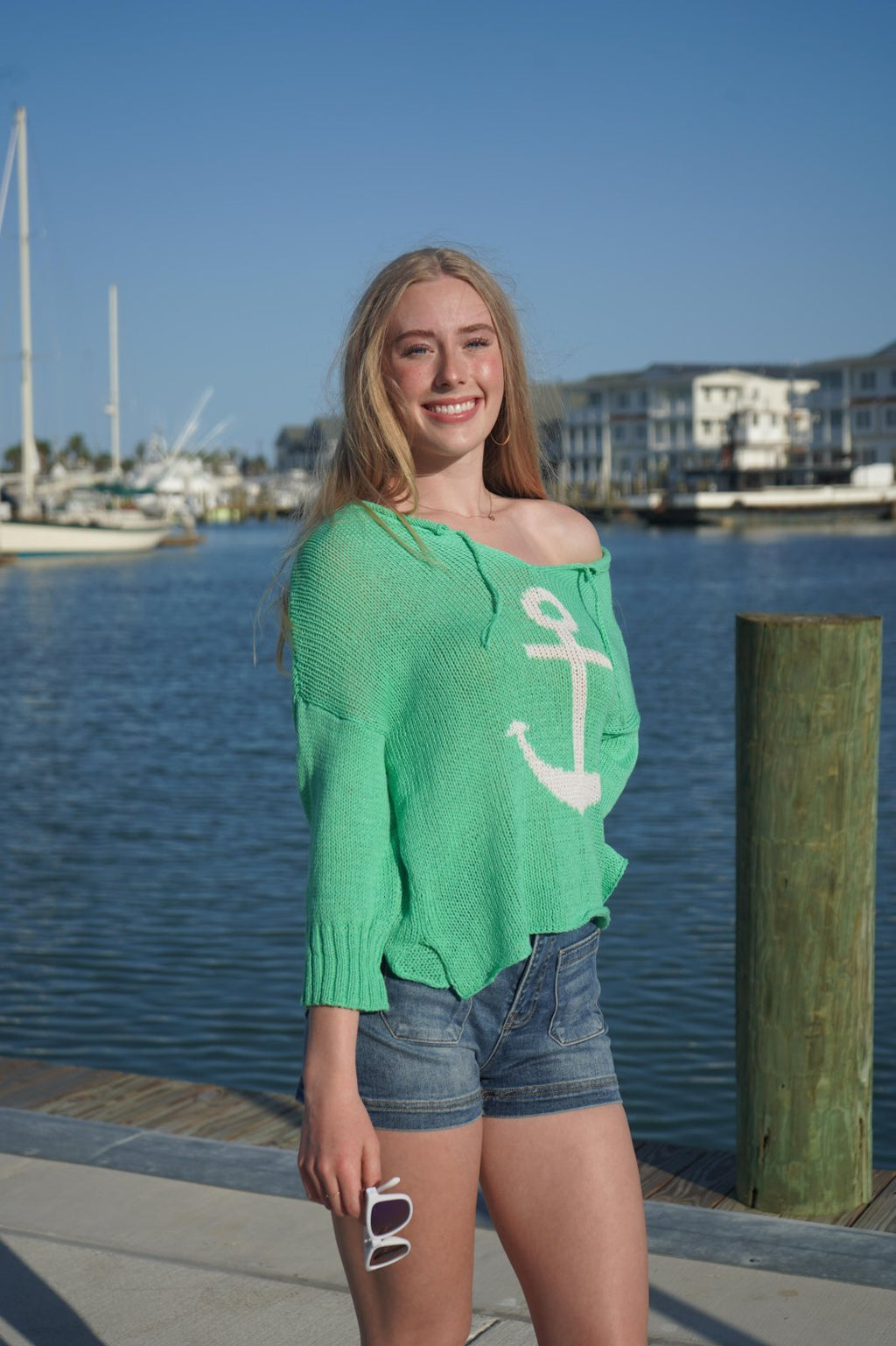 Model wearing a green Wooden Ships Anchor Sweater, perfect for coastal boutique clothing and tropical vacations.