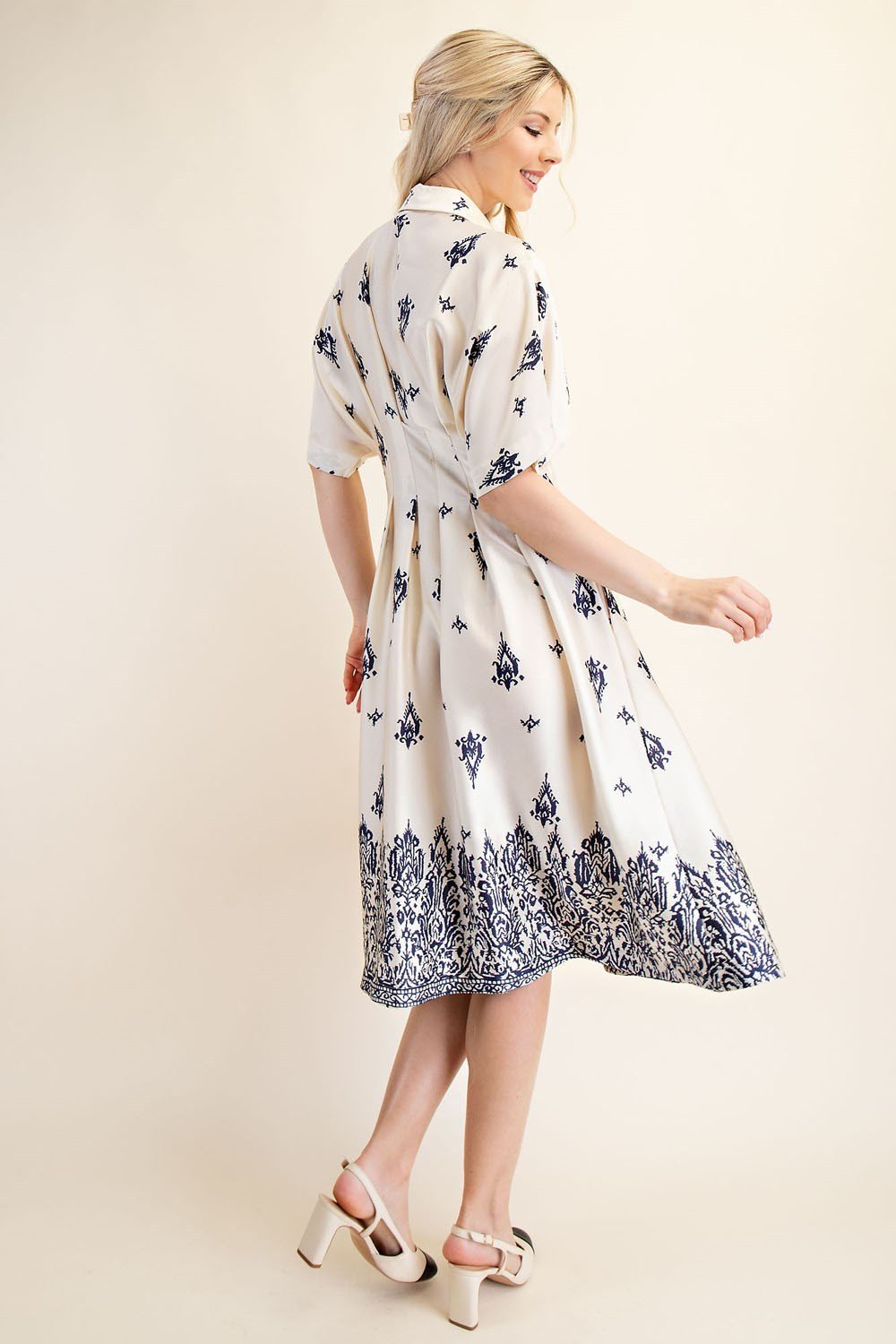 Elegant navy midi dress with a pleated skirt, perfect for coastal boutique clothing and tropical vacations.