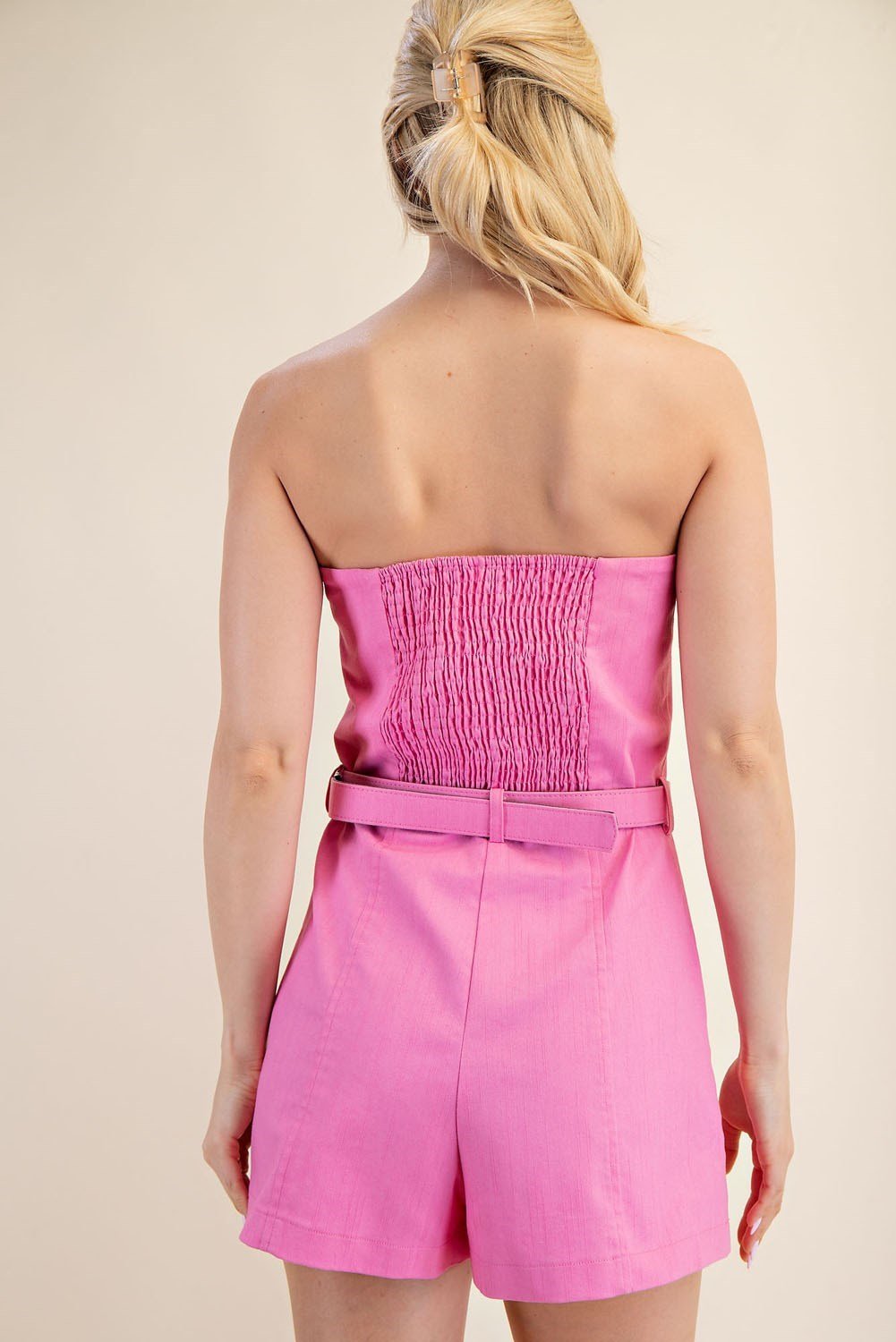 Back view of the Eden Romper, a pink strapless jumpsuit perfect for tropical vacation dresses at a coastal boutique.