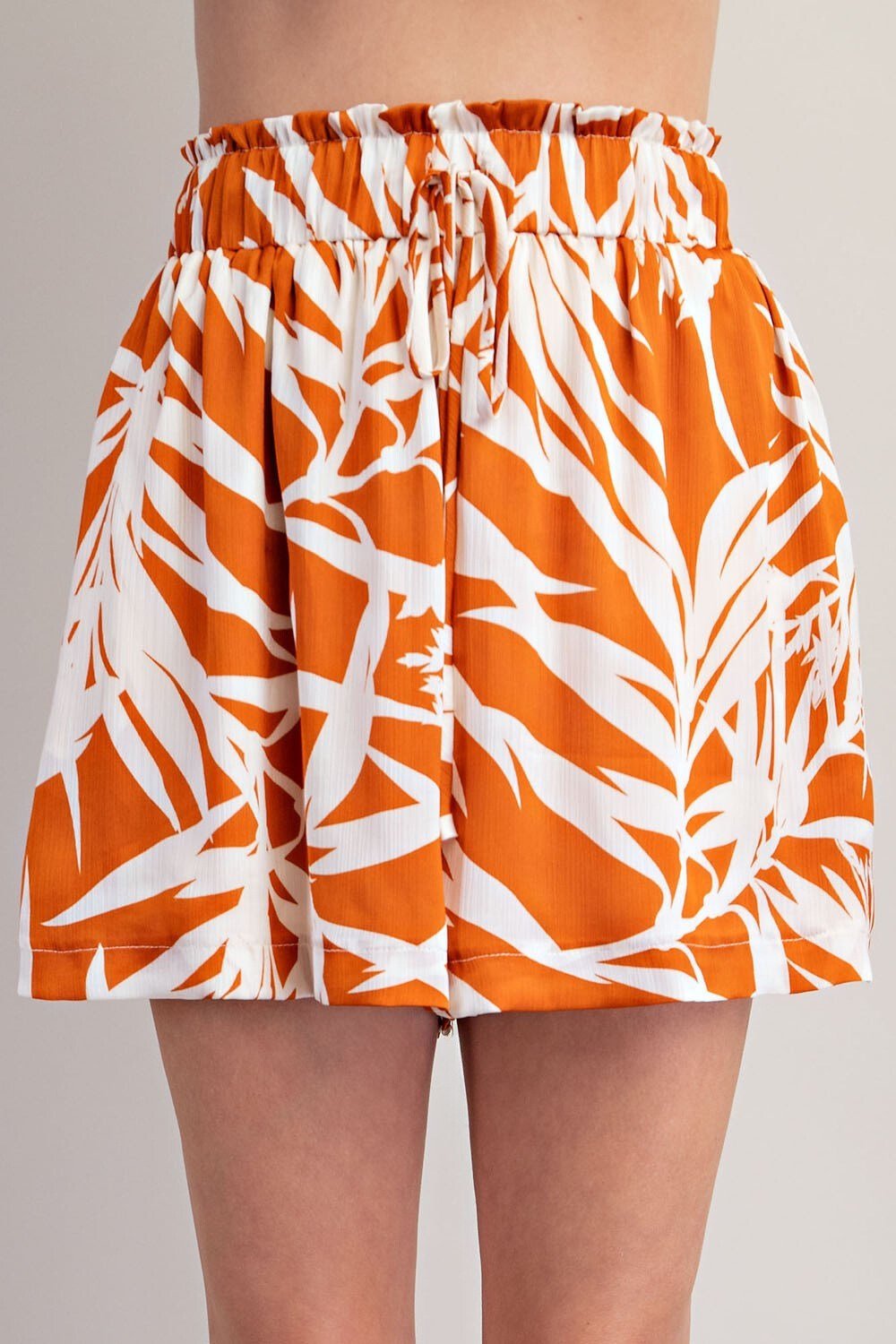 CAMEL SHORTS in vibrant orange and white tropical print, ideal for coastal fashion and summer outfits Texas.