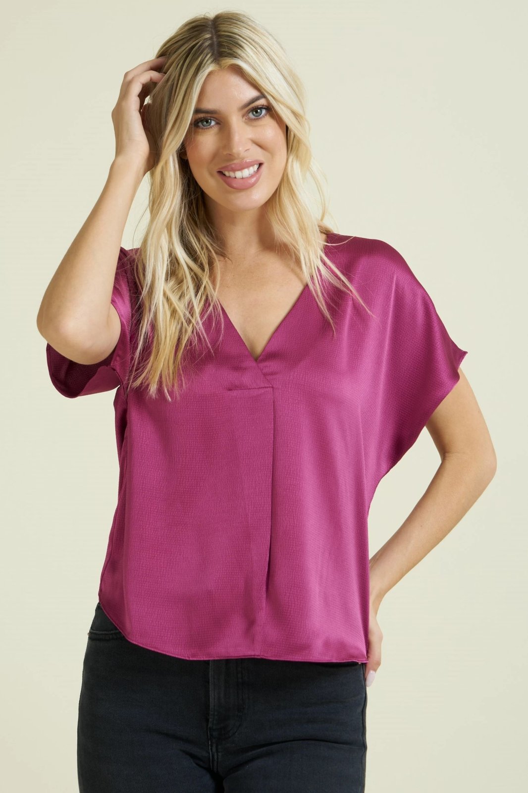 Woman wearing a MAGENTA TEXTURED SATIN TOP from Raggdoll Boutique, ideal for trendy coastal style and summer outfits Texas.
