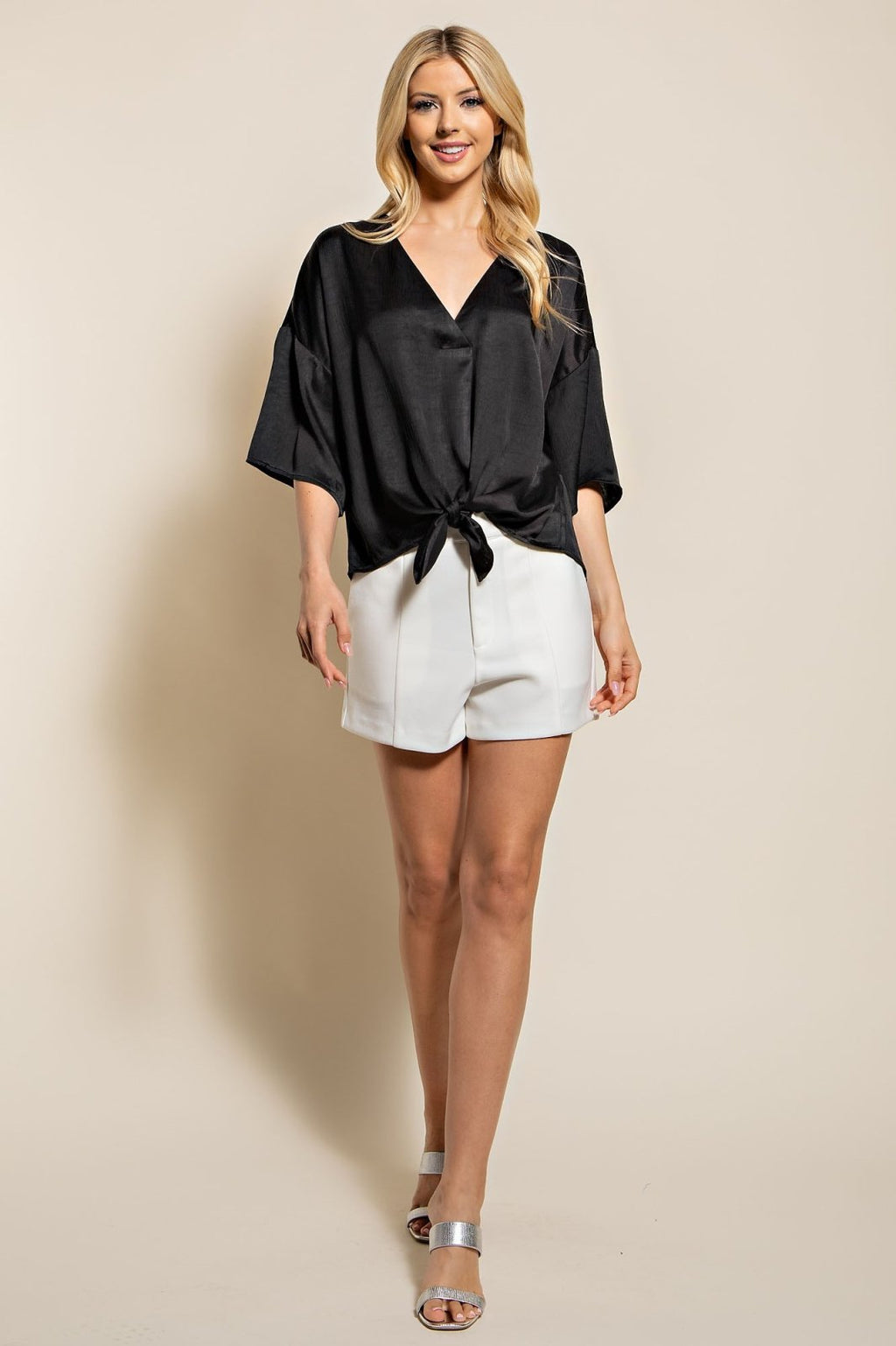 Model wearing BLACK TIE-FRONT TOP with white shorts, showcasing trendy coastal style from Raggdoll Boutique.