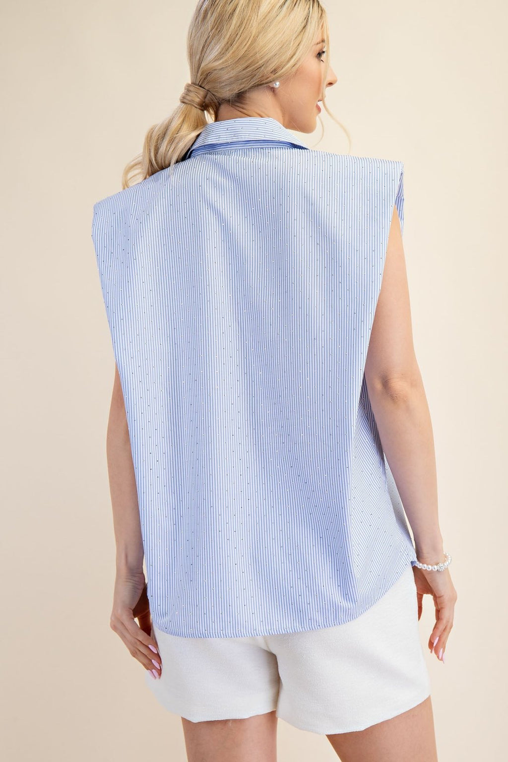 Sky blue shoulder pad shirt from a coastal boutique, perfect for summer outings and beach dresses.
