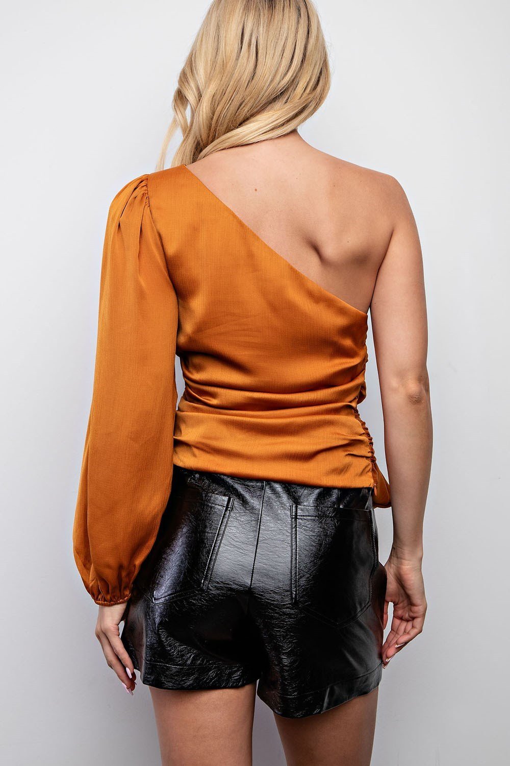 Woman wearing CAMEL SATIN OFF SHOULDER TOP with trendy black shorts, showcasing summer outfits Texas.