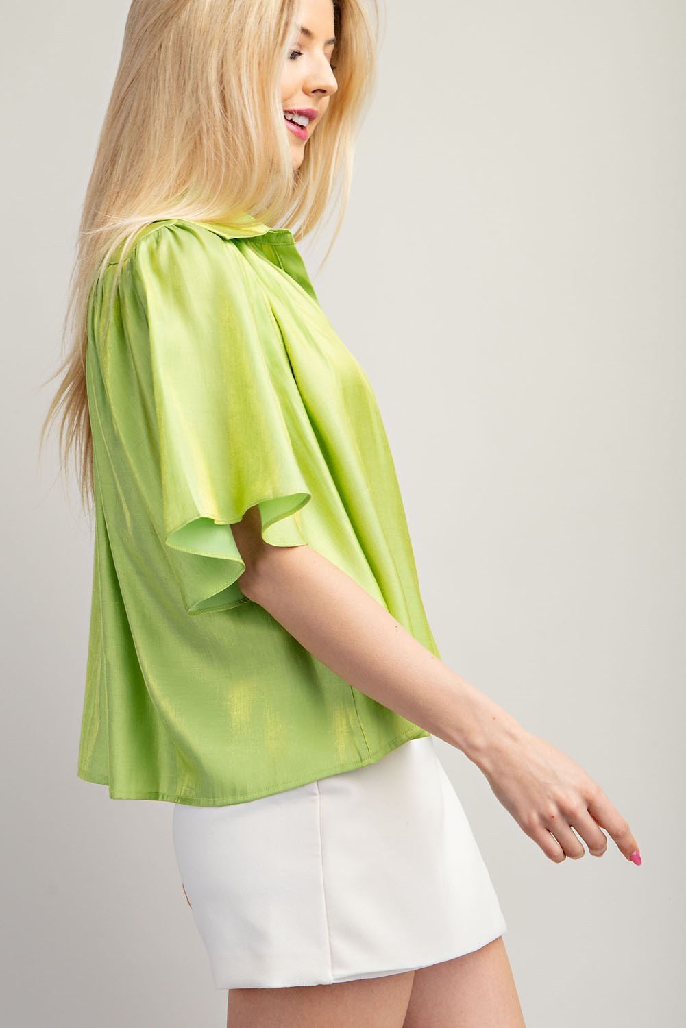 Lime Sparkle Button-up Flowy Top styled with white shorts, perfect for a trendy coastal fashion boutique look.