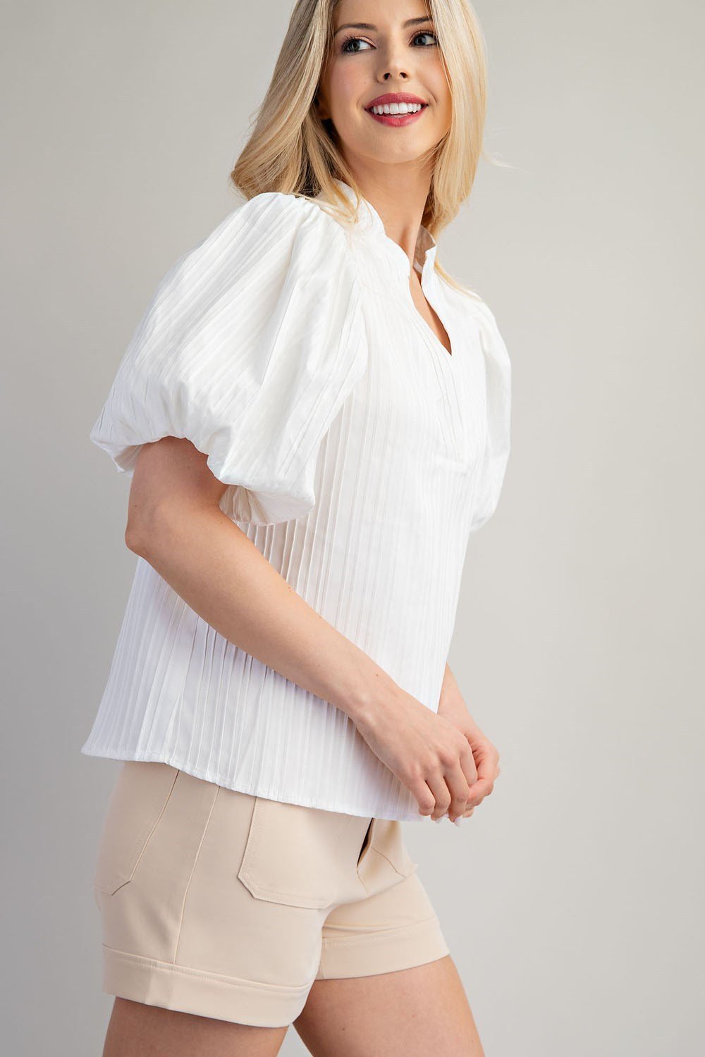 Model showcasing GLAM (WHITE) V-NECK PUFF SLEEVE TOP styled with shorts from Raggdoll Boutique.