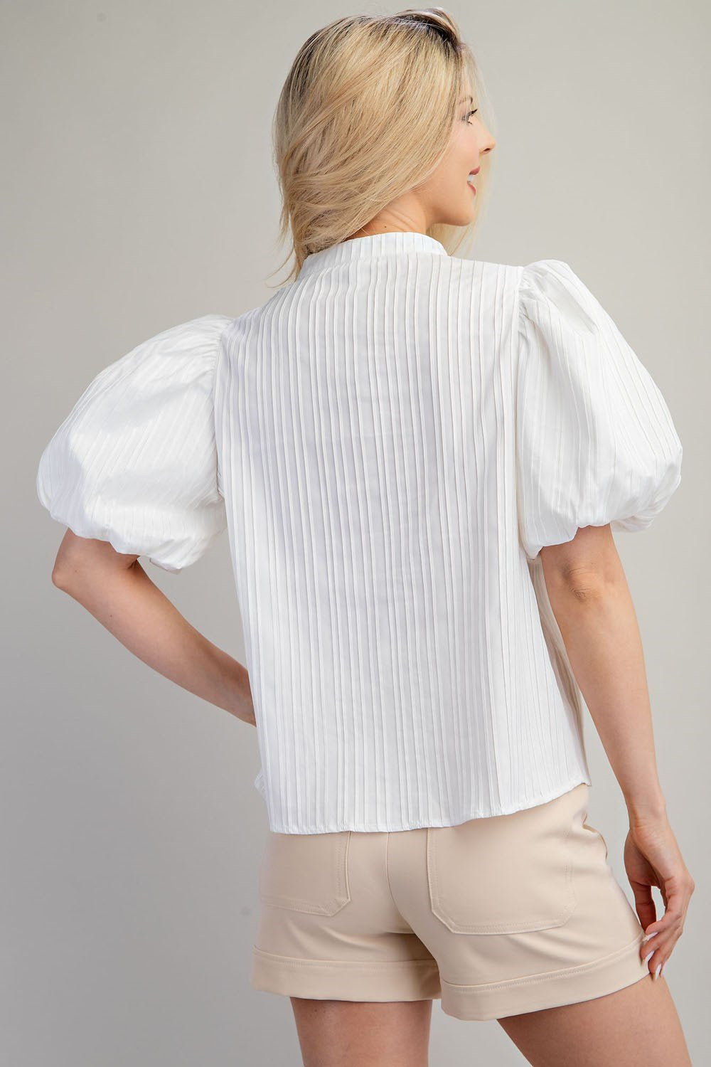 Model showcases the GLAM (WHITE) V-NECK PUFF SLEEVE TOP paired with shorts, perfect for trendy coastal style.