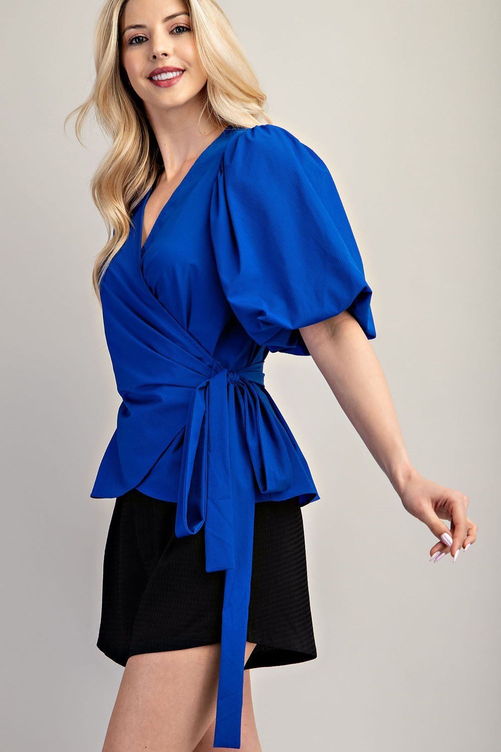Stylish Marlin Blue Wrap blouse, perfect for coastal boutique clothing, paired with women's bottoms for a chic look.