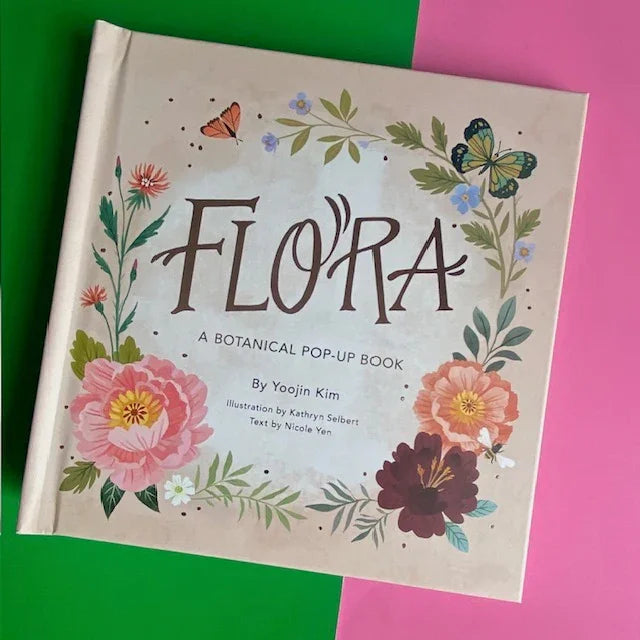 FLORA BOTANICAL POP-UP BOOK featuring vibrant floral illustrations and butterflies on a pastel background.