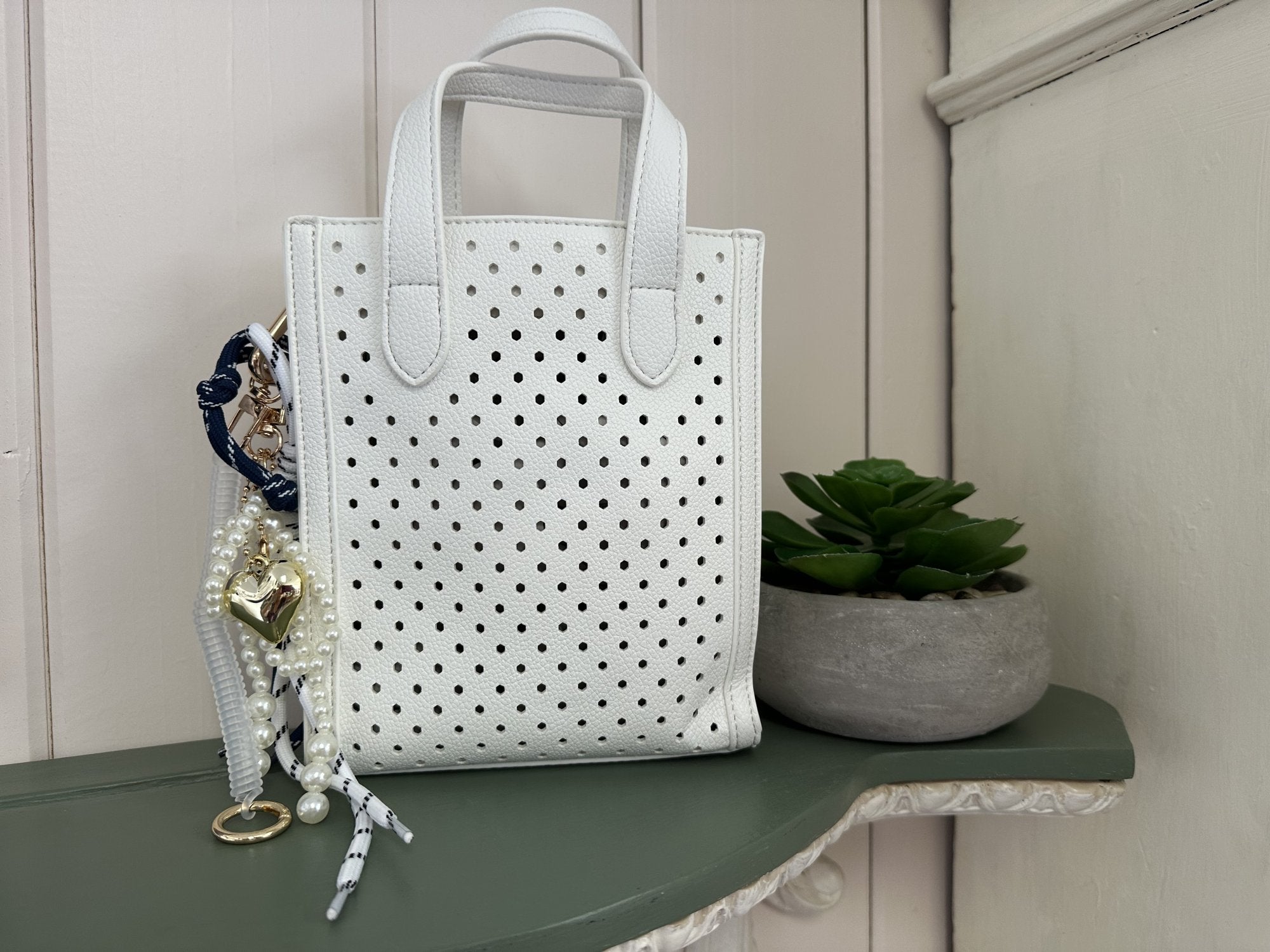Ines Purse in White: lightweight perforated faux leather crossbody handbag, perfect for summer beach outfits and trendy accessories.