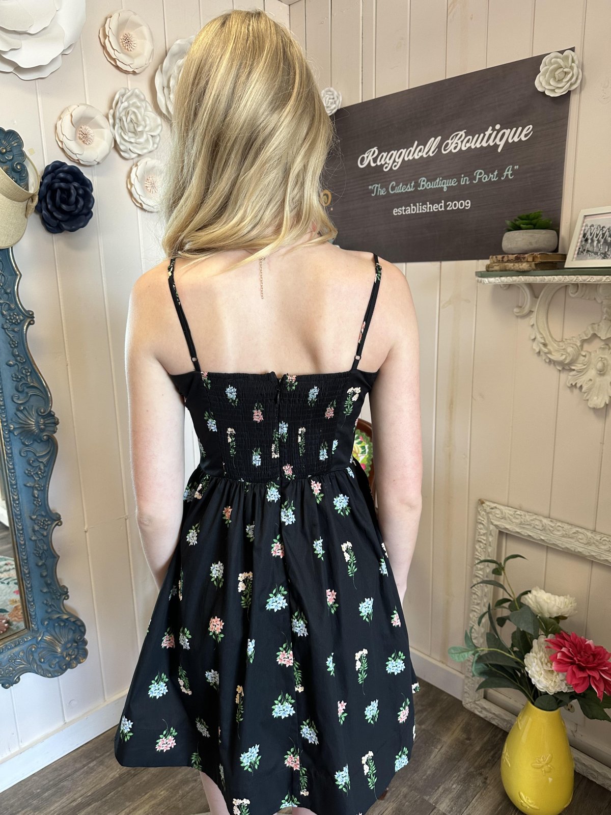 Back view of Myra Dress, a floral fit and flare mini dress, perfect for coastal boutique clothing and tropical vacation outfits.