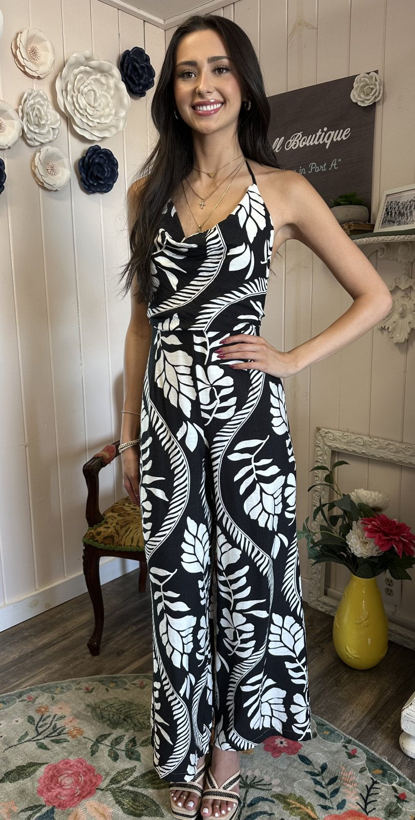 Stylish black and white floral Malia jumpsuit, perfect for summer events from a Port Aransas boutique, paired with trendy accessories.