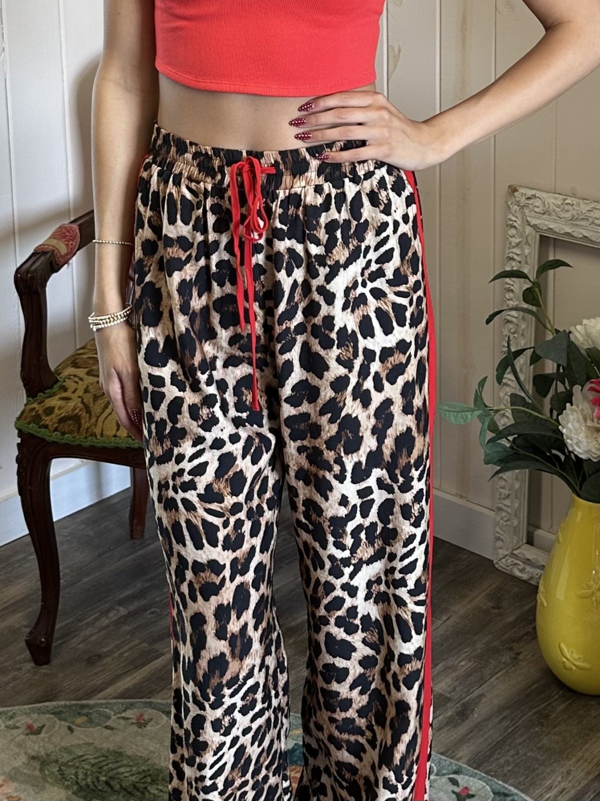 Leopard printed track pants with red side stripes for a chic athleisure look, perfect for coastal boutique clothing lovers.