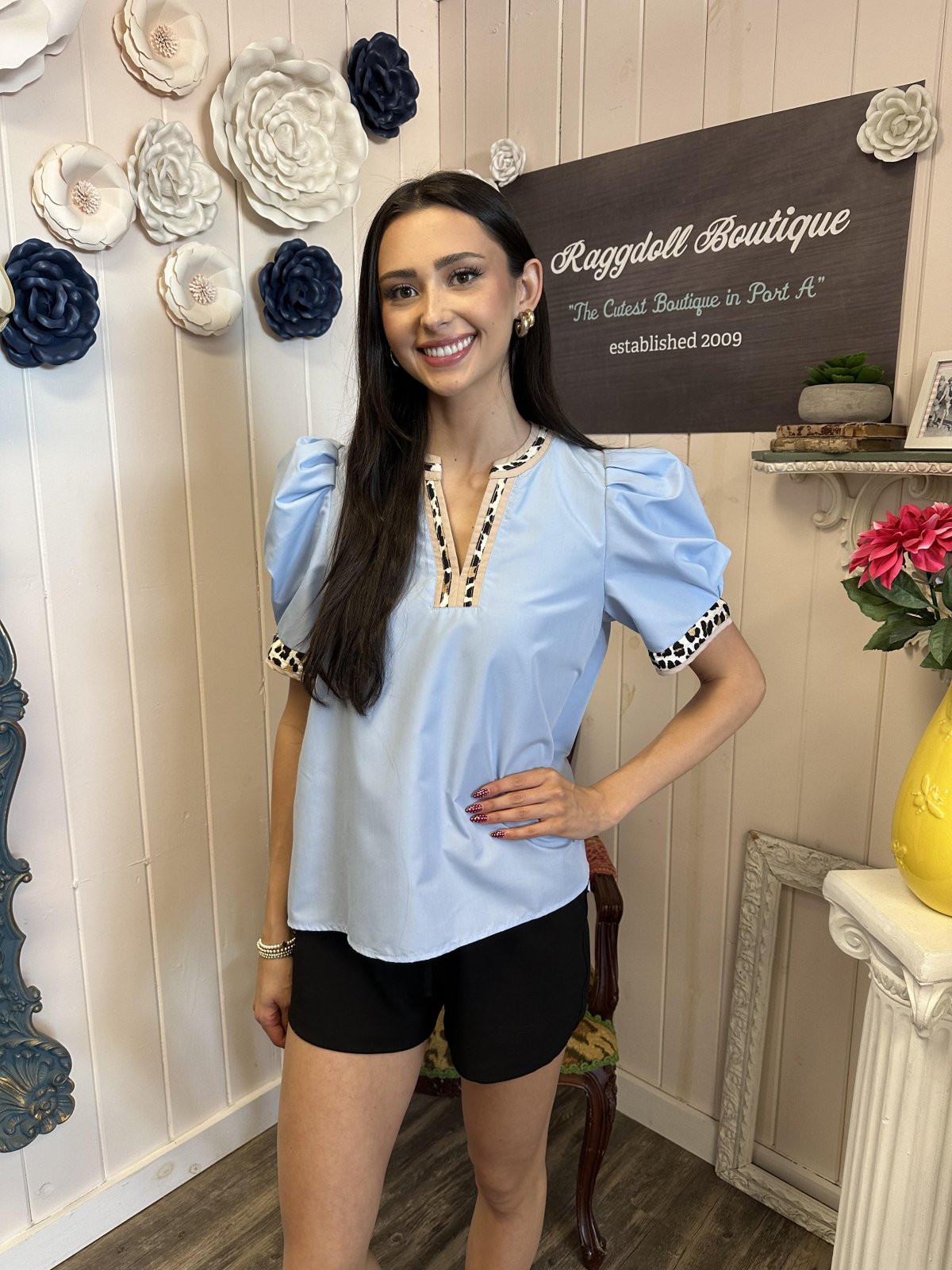 Light blue pleated top with leopard print split V-neck, stylish for coastal boutique clothing and casual beach vibes.