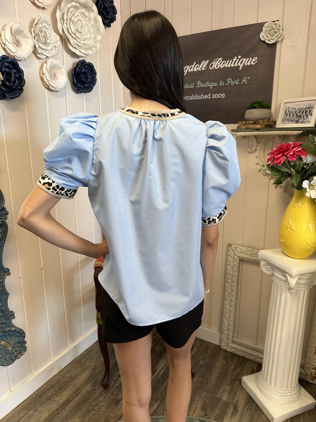 Light blue pleated top with leopard print detail, perfect for coastal boutique clothing and casual beach fashion.