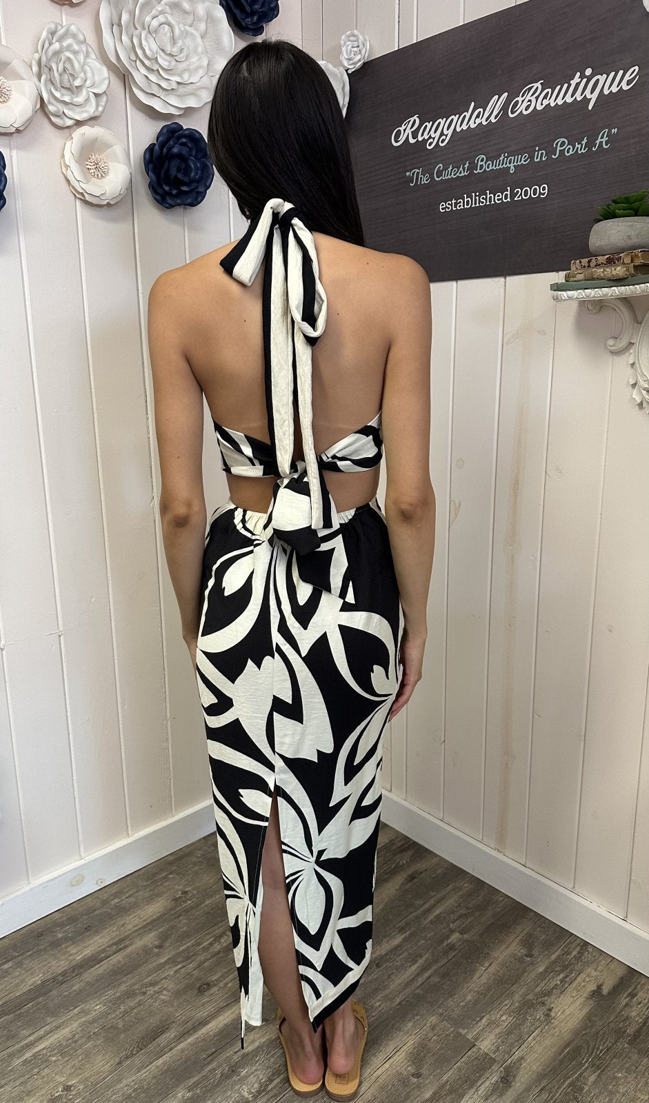Back view of black tropical print criss-cross halter midi dress, perfect for coastal boutique clothing and beach dresses.