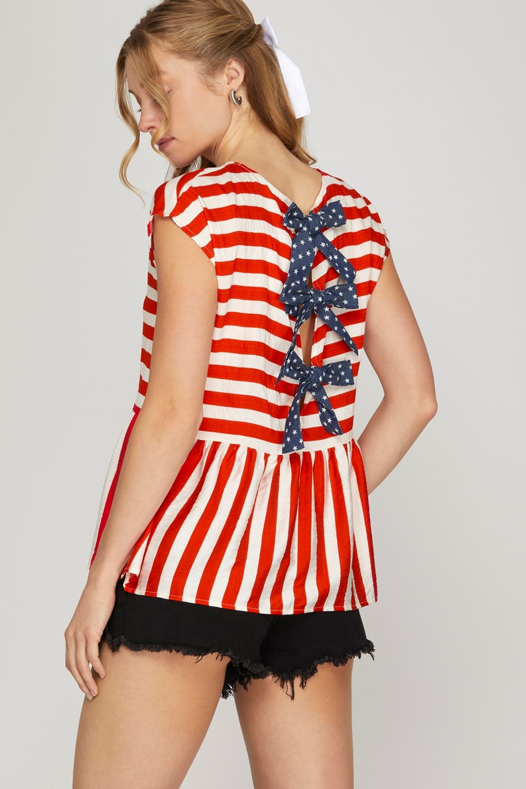 Stylish red striped drop shoulder top with bow ties, perfect for coastal boutique clothing or casual outings.
