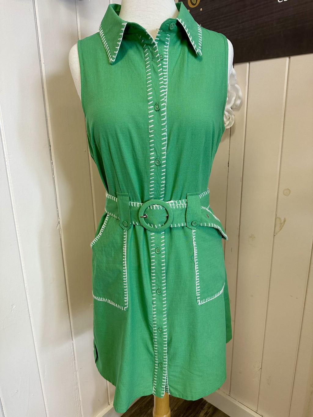 Green sleeveless Daisy Dress with button-down front, contrast stitching, and matching belt, ideal for coastal boutique clothing.