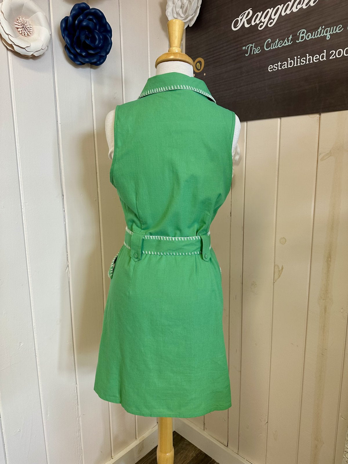 Back view of green Daisy Dress with button details and waist belt from a Port Aransas boutique, perfect for tropical vacations.
